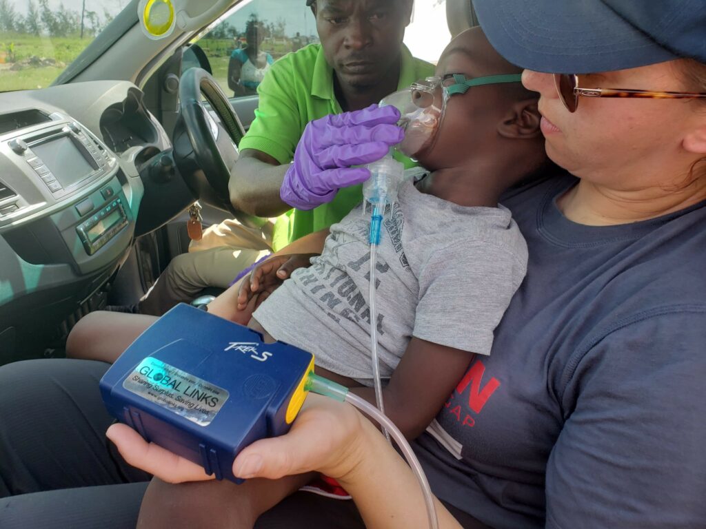un niño usando un nebulizador azul con una calcomanía donada por Global Links