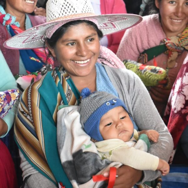Mother in traditional Bolivian clothing holder her child.